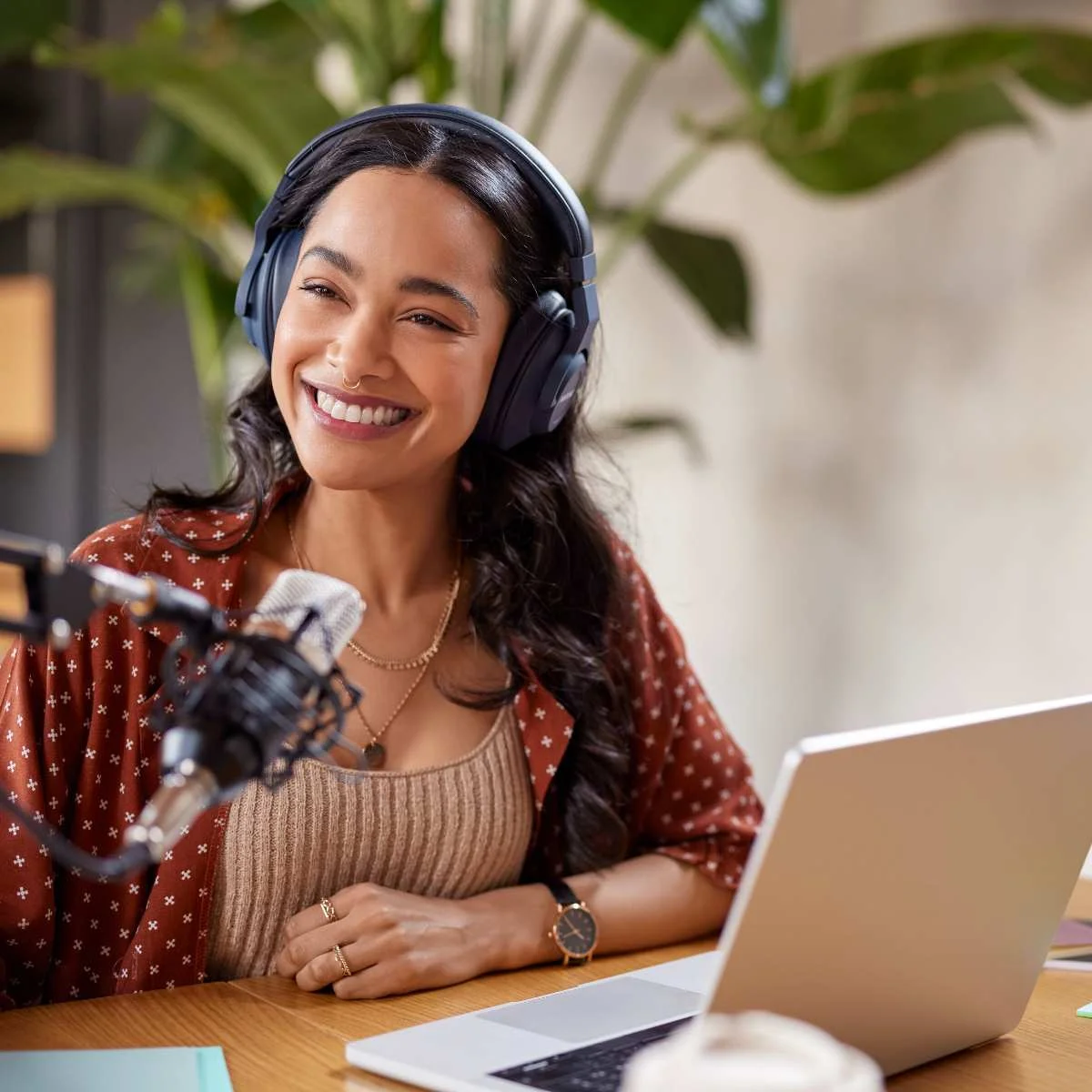 Coach smiling at her desk with a microphone and laptop